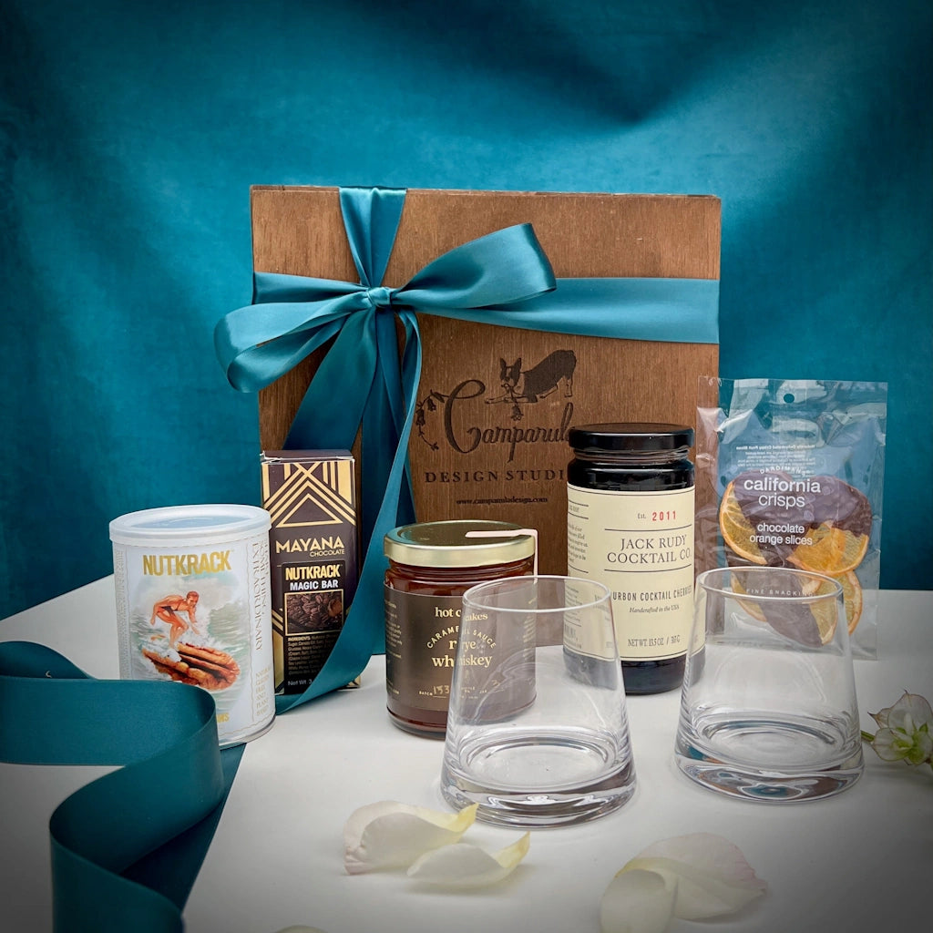 Nationwide shipping is available for this delightful gift box inspired by cocktails. Whiskey caramel sauce, whiskey glasses, flavored pecans, chocolate dipped orange slices, nutcrack magic bar, and Jack Rudy cocktail cherries are among the items in this gift for your cocktail loving friend.