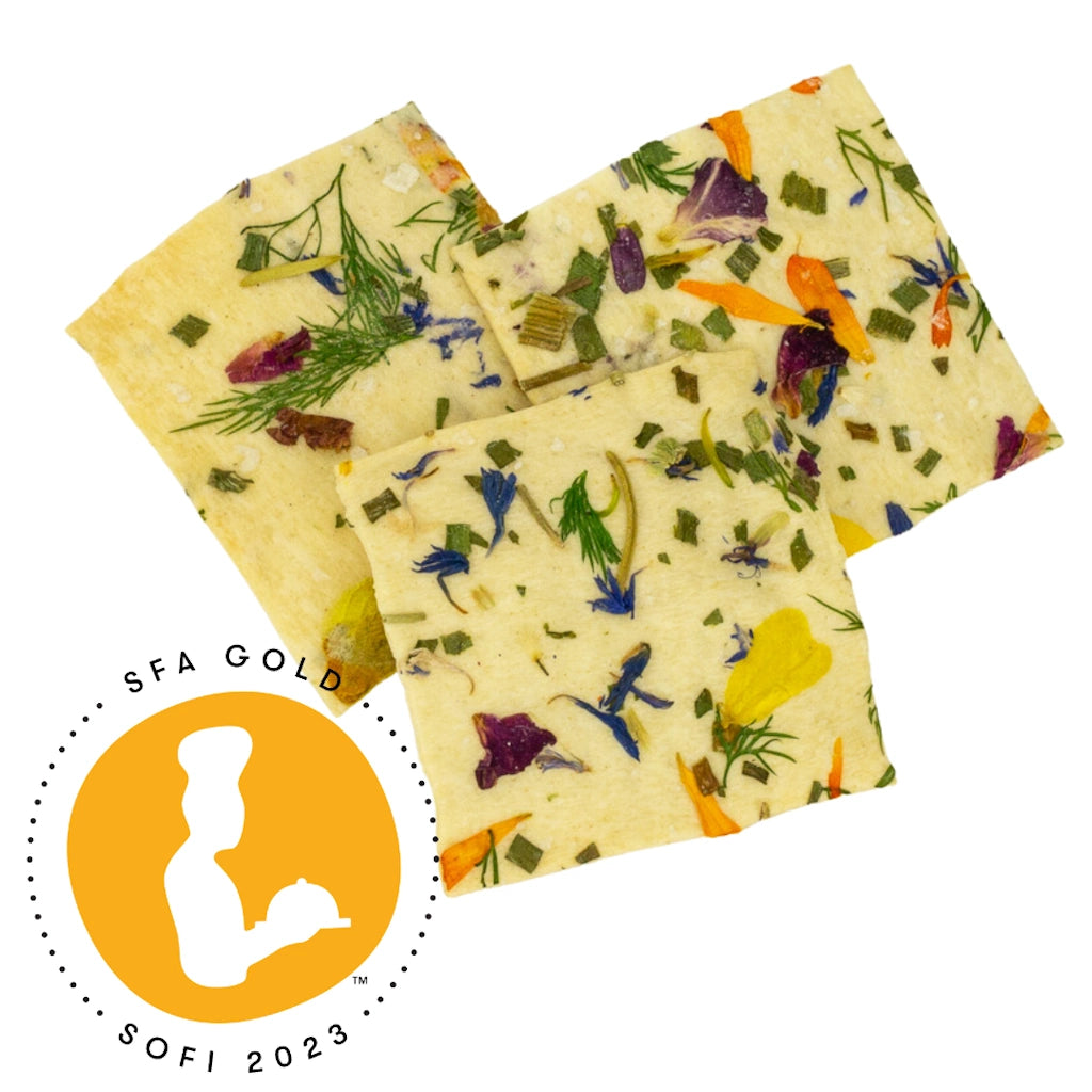 Three square crackers with floral and herb patterns on a white background, featuring the SFA Gold SOFI 2023 award logo.