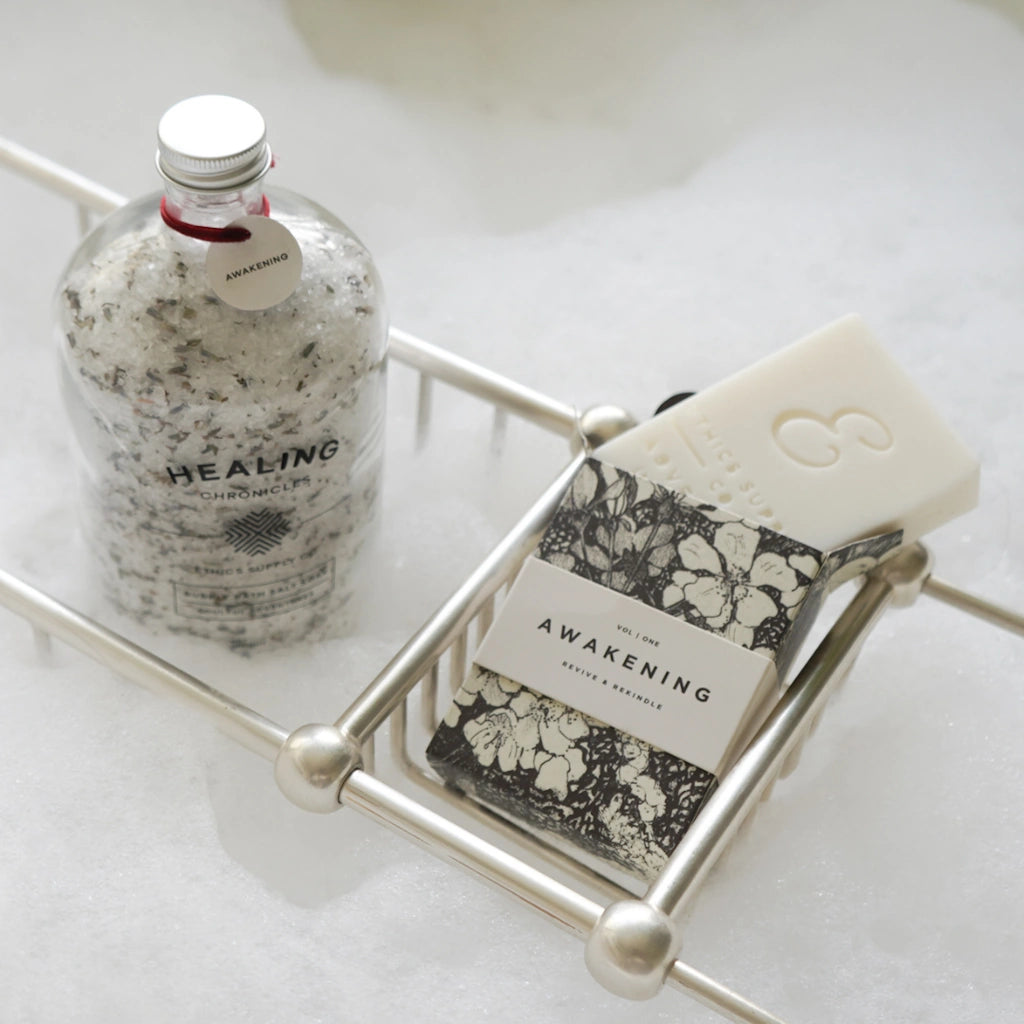 Bottle, soap, and jar on a metal tray with 'Healing' and 'Awakening' text.