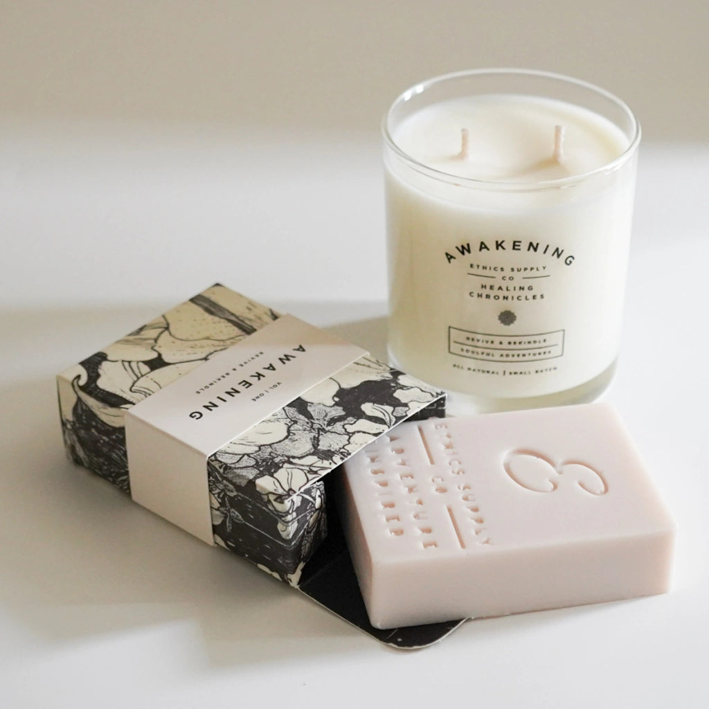 Candle and soap with 'Awakening' branding on a light background