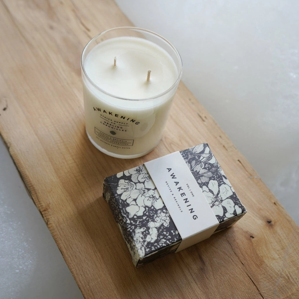 Candle and its packaging labeled 'Awakening' on a wooden surface