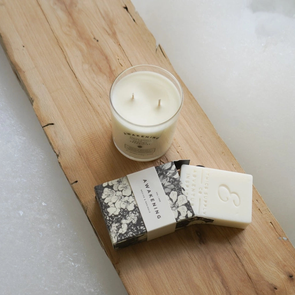 Candle and soap on a wooden board with a white background
