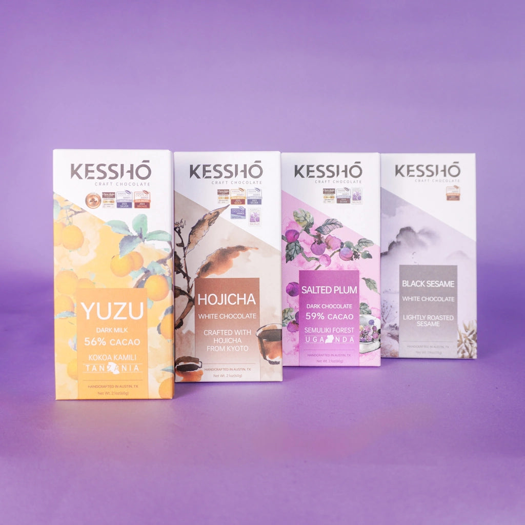 Four Kesshõ chocolate bars with different flavors on a purple background.  Available for sale from Campanula Design Studio, Seattle florist and gift basket company in the Magnolia neighborhood.