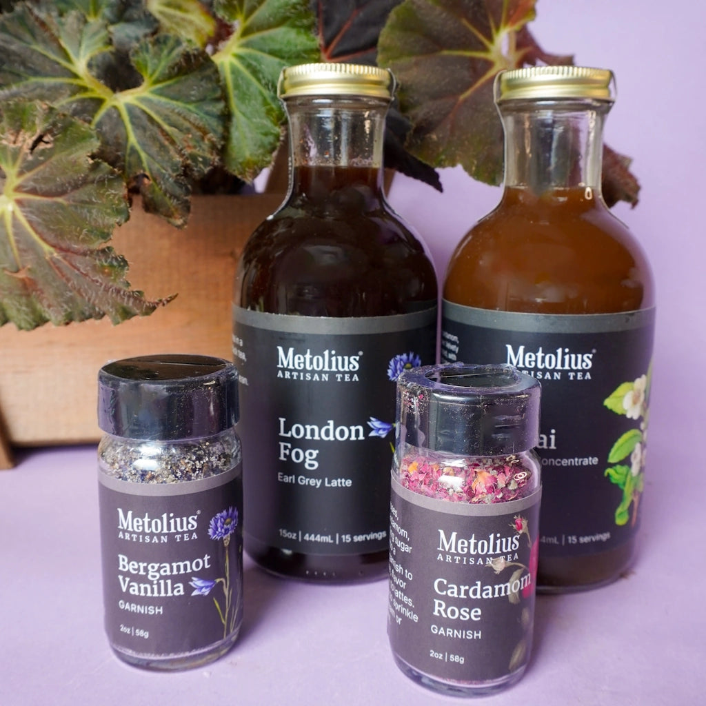 Metolius Artisan Tea bottles on a purple surface with a plant in the background