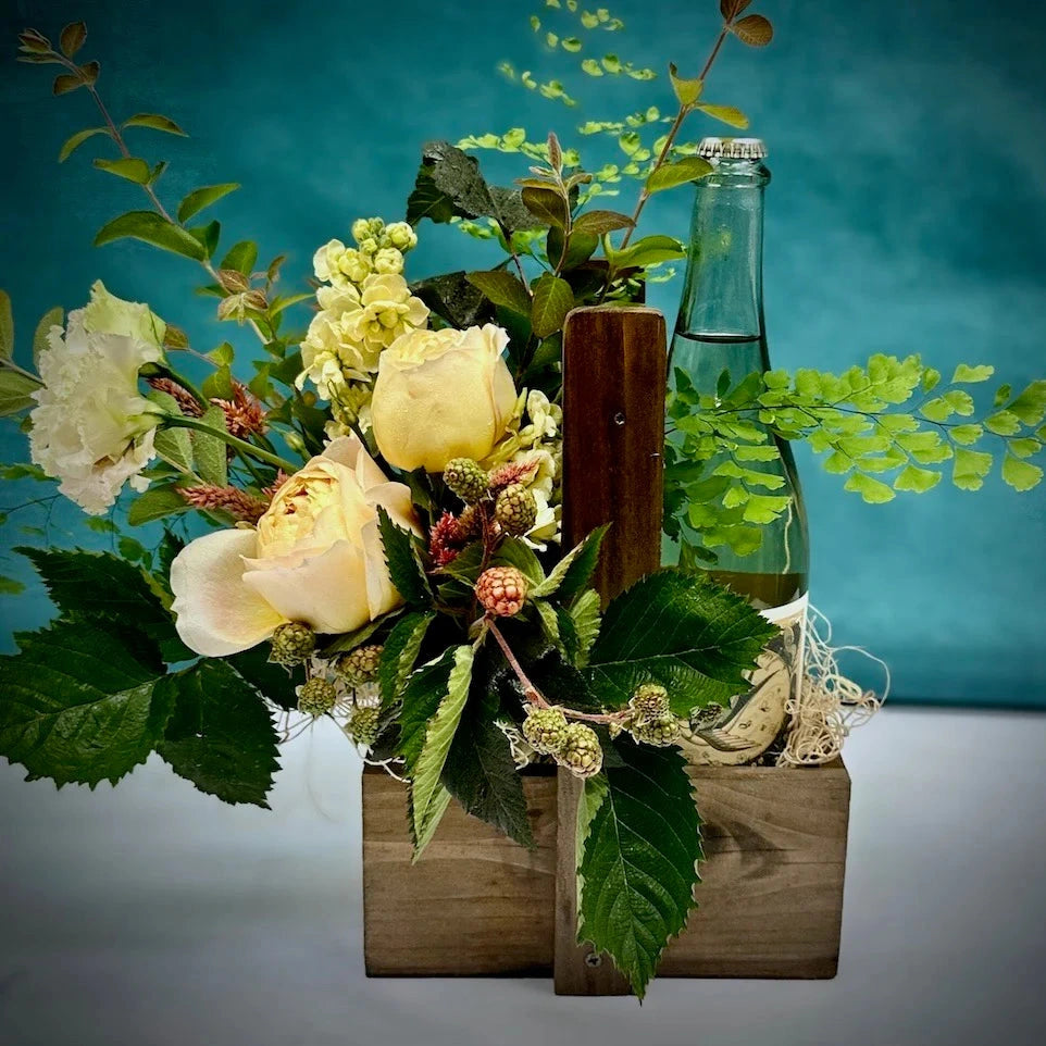 Campanula Design's handcrafted wooden wine caddy perfectly holds a designer's choice bud vase of flowers and a bottle of wine. Custom add-ons available.