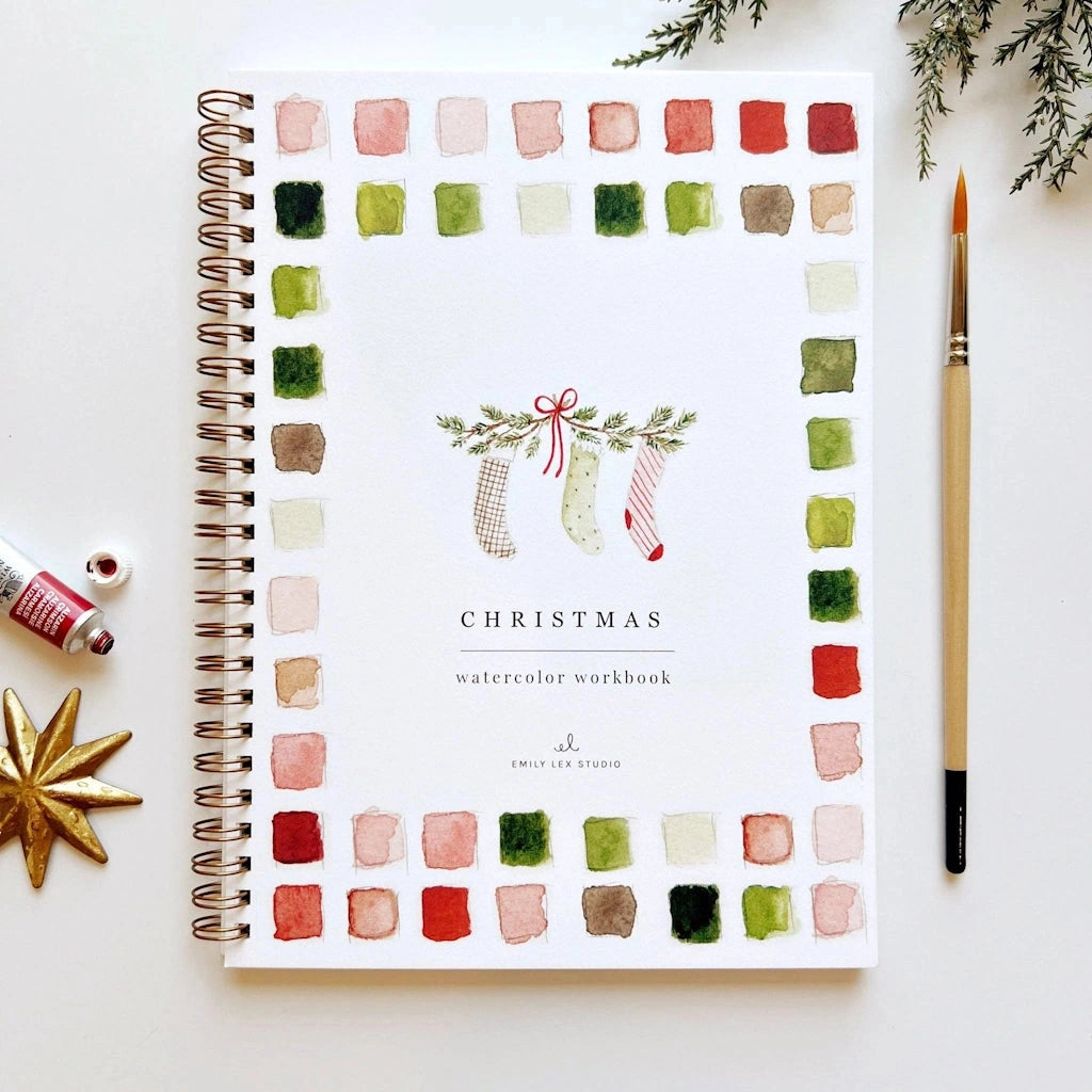 Christmas watercolor workbook with color swatches and a pen on a white background.  Available for sale from Campanula Design Studio, Seattle florist and gift basket company in the Magnolia neighborhood.