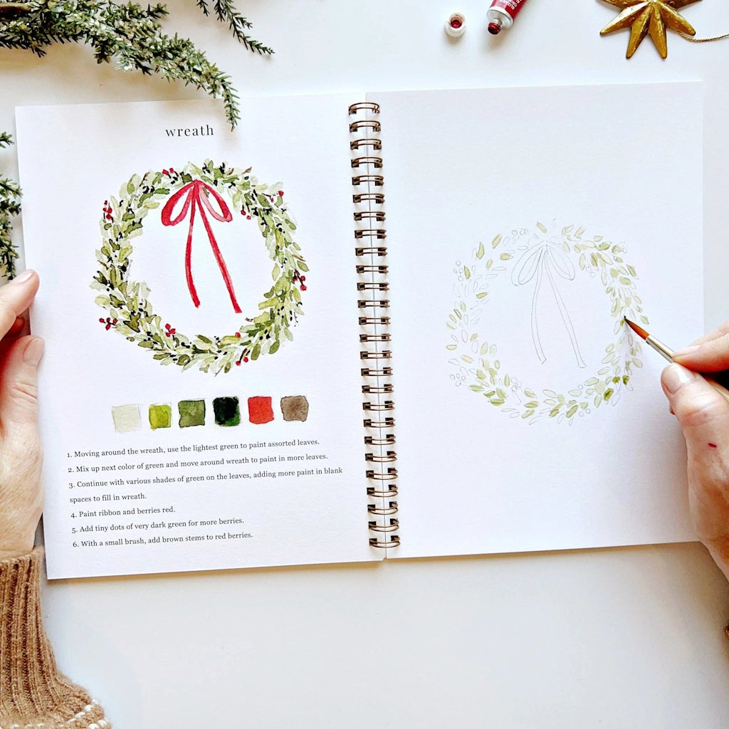 Open book with illustrations of wreaths and color swatches on a white surface.  Available for sale from Campanula Design Studio, Seattle florist and gift basket company in the Magnolia neighborhood.