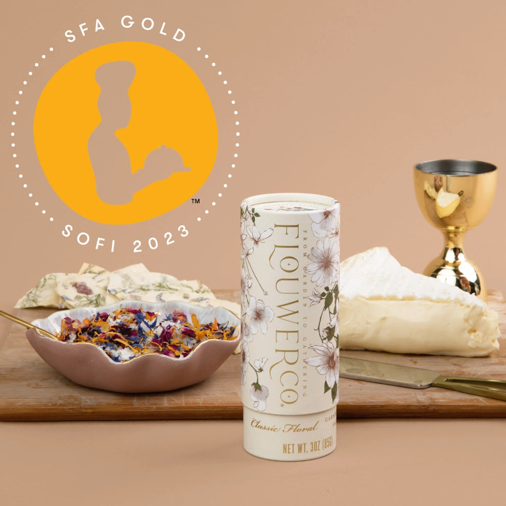 Garnishing salt with 'SFA Gold' and 'SOFI 2023' award logo on a table with food items.