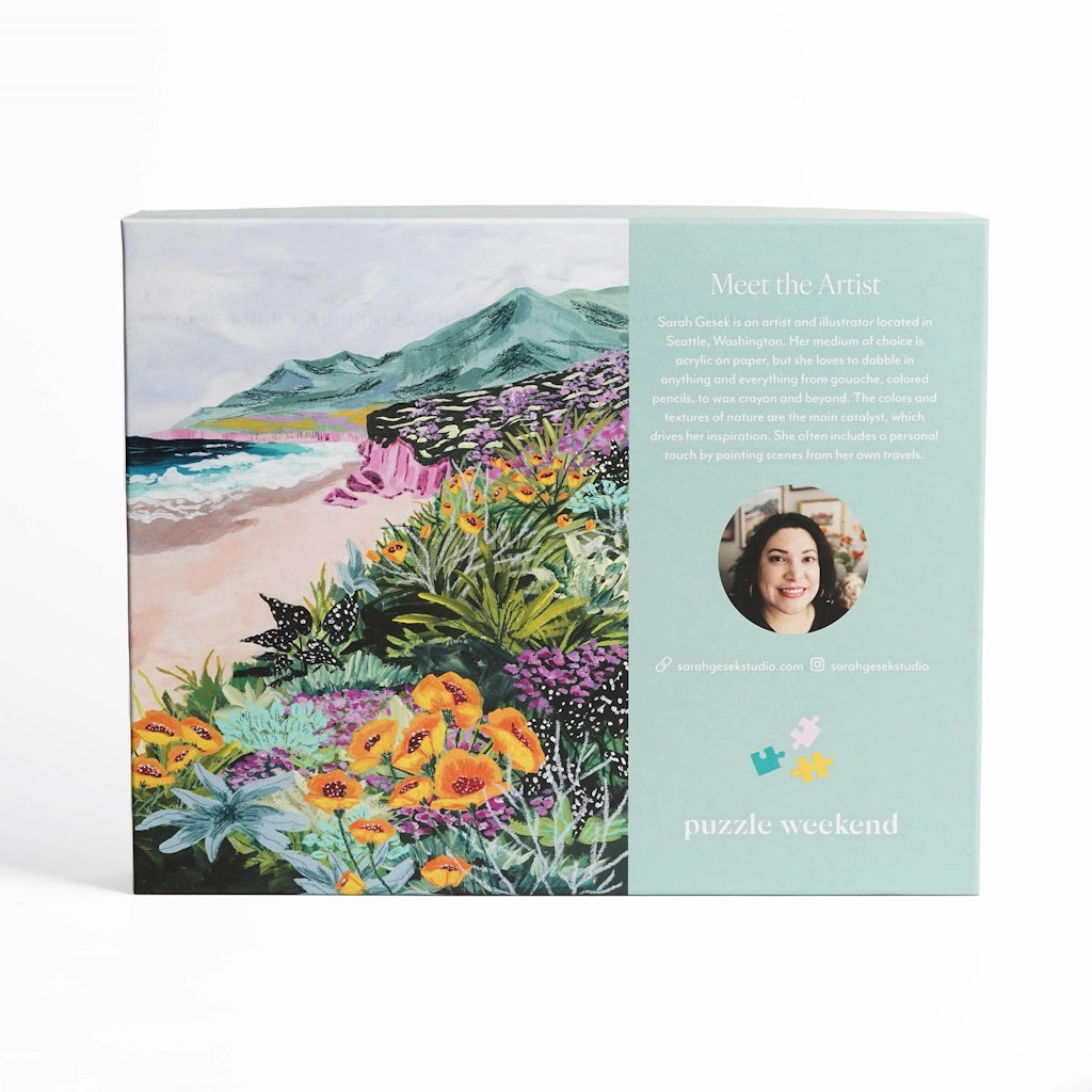 Puzzle packaging with a scenic illustration and artist's profile on a light blue background.  Available from Campanula Design Studio, Seattle florist and gift basket company in Magnolia.