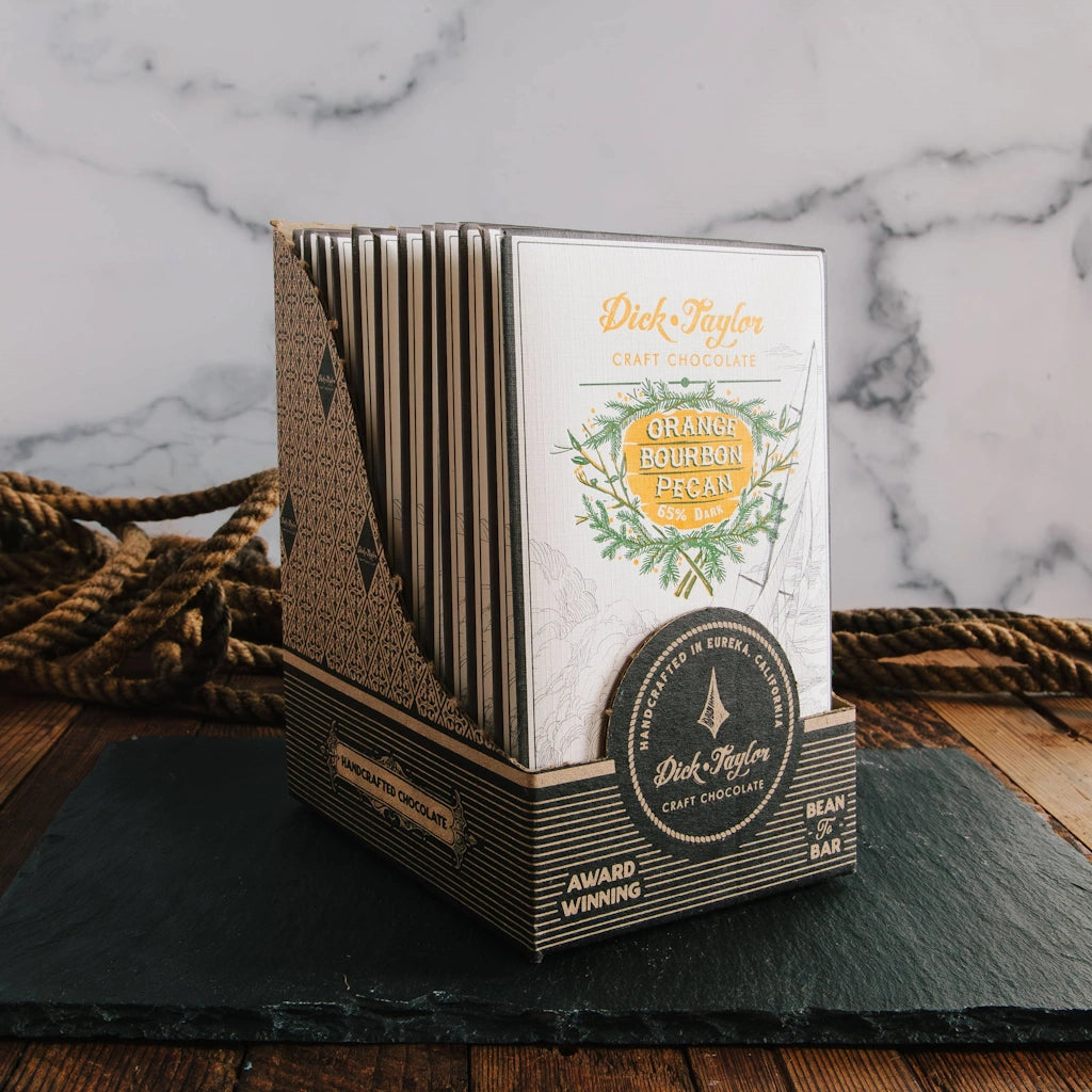 Chocolate bar packaging with branding on a marble and wooden surface