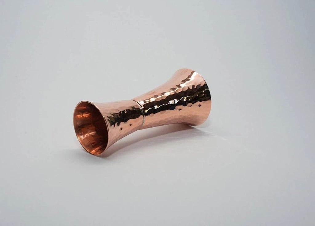From Campanula Design Studio: Sertodo Copper Double Sided Copper Jigger.  Elegant hourglass shape copper jigger with precise measurements punched into the body. 2 ounce and 1 ounce cups soldered together, with 3/4, 1 1/2 ounce and 1/4, 1/2 ounce indentations struck into each cup for an accurate pour.