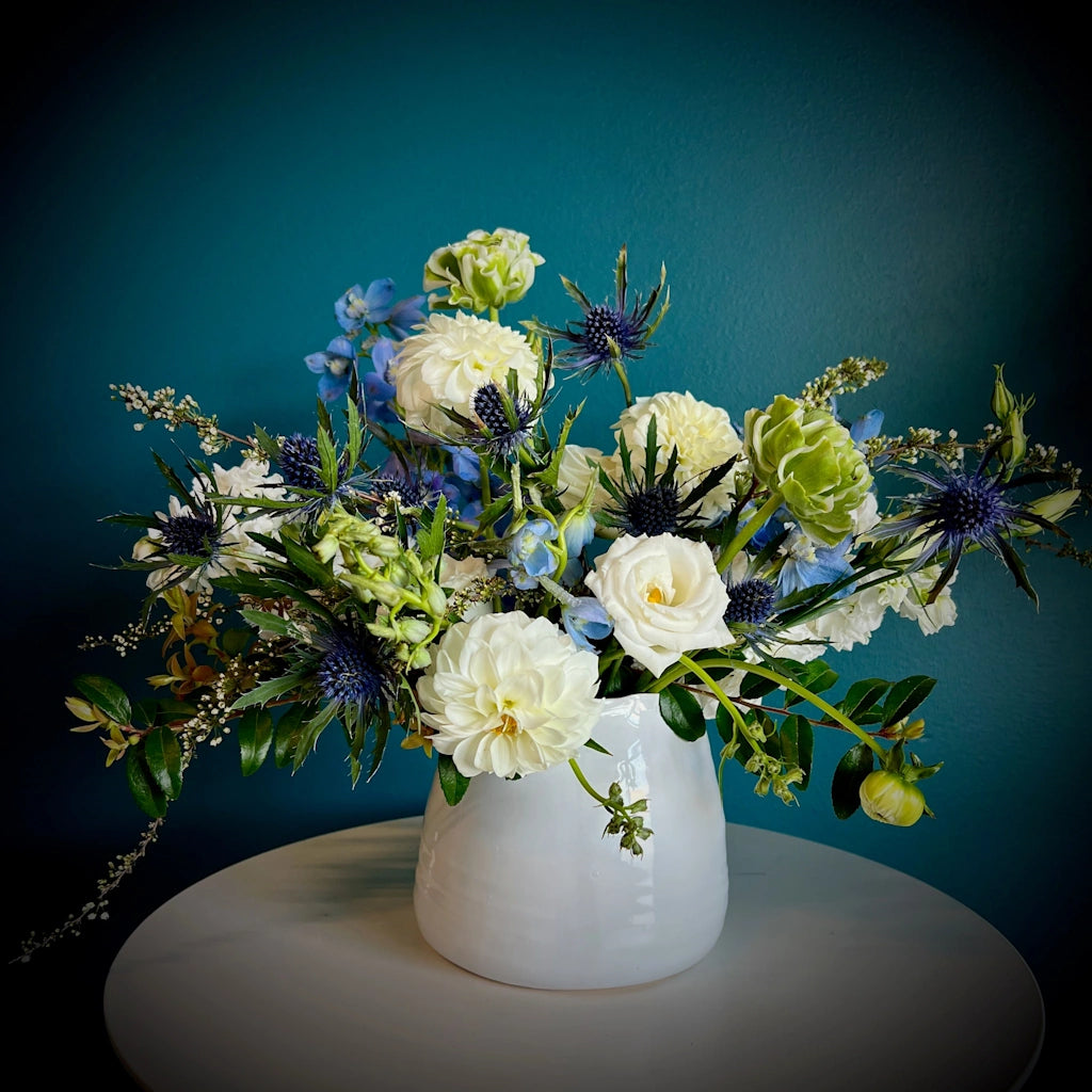 We call this floral arrangement "Dream a Little Dream" - it features a dreamy palette of blues, whites, and just a subtle pop of soft peach designed in a ceramic vessel. Available in our shop in Magnolia in Seattle at 4009 Gilman Ave W or for delivery in the Greater Seattle area.