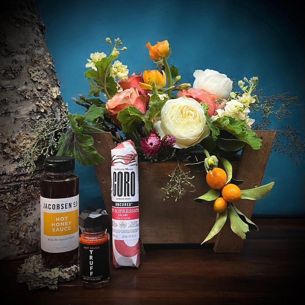 This spicy gift basket from Campanula Design includes a seasonal flower arrangement, a bottle of Jacobsen Salt Co.'s, a Hot Honey Sauce with Scorpion Chili, a Mini Bottle of Truff Hot Sauce and Coro Foods Hot Soppressata Salami