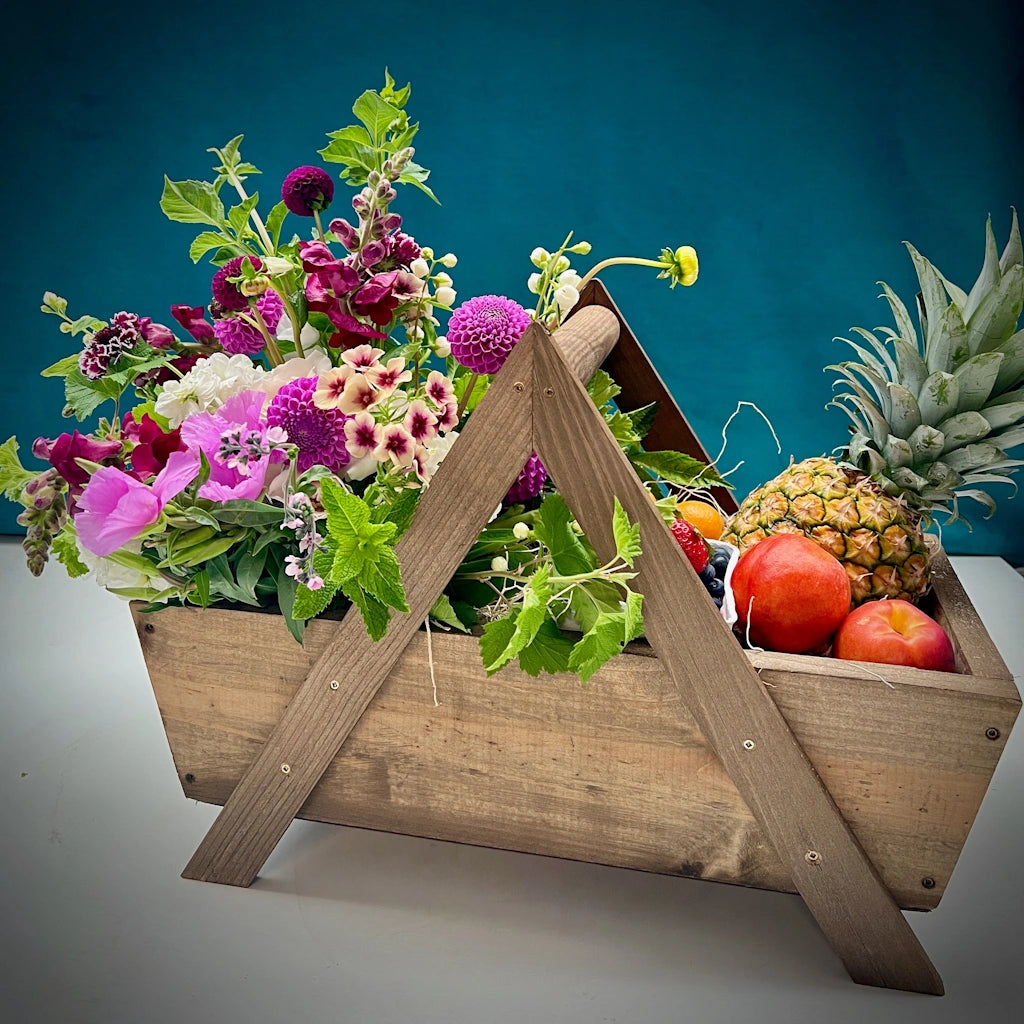 Gift basket featuring a selection of seasonal, organic fruit and fresh flowers beautifully designed in our signature wooden basket from Campanula Design Studio.