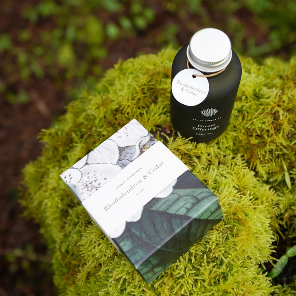 Black bottle and box with a white label on green moss