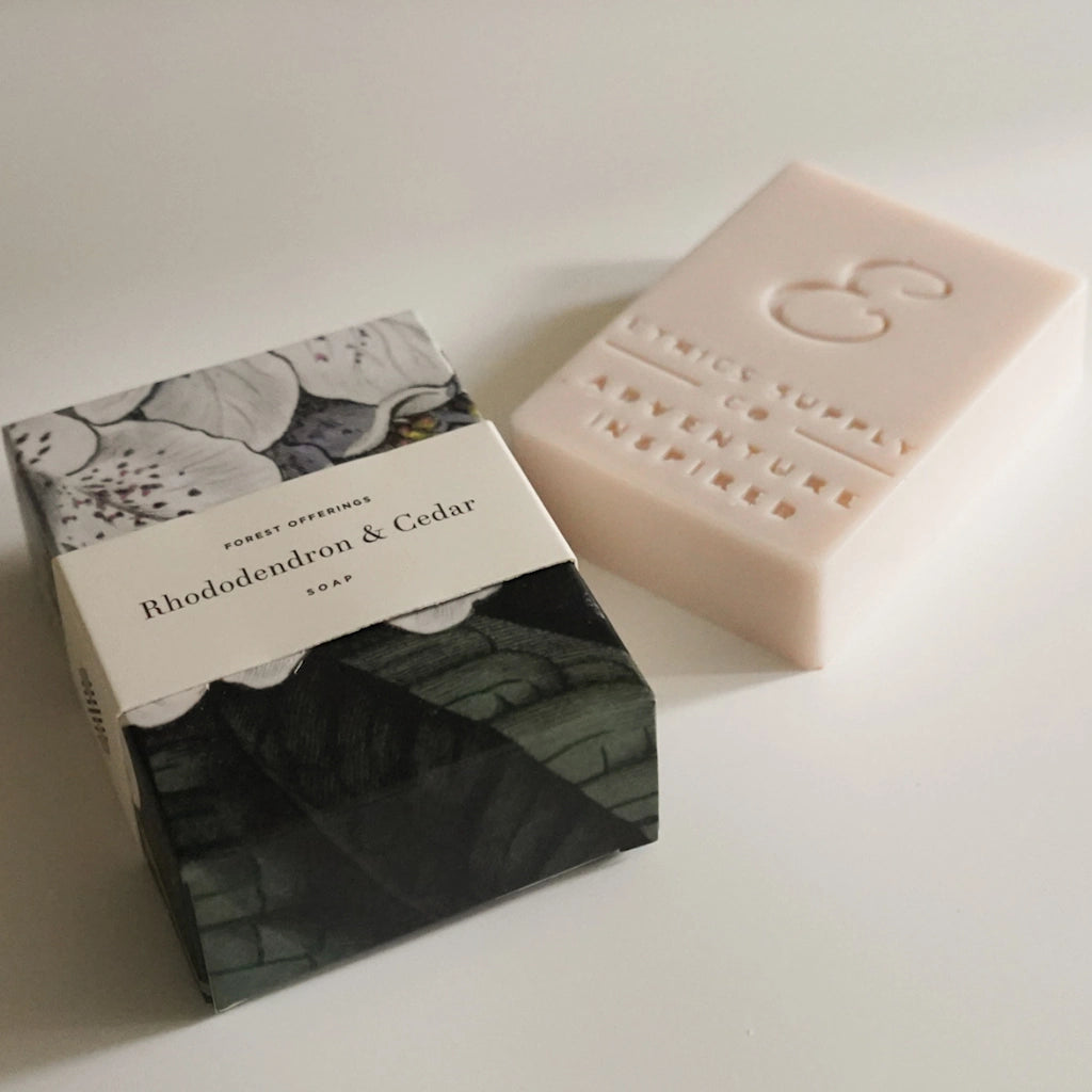 Bar of soap and its packaging on a white surface