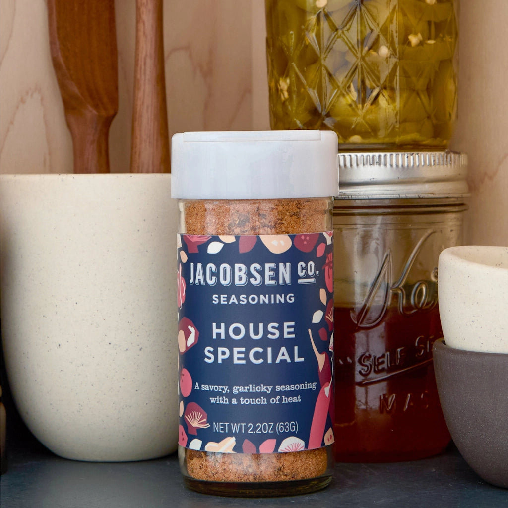 Jar of Jacobsen Co. House Special seasoning with kitchen items in the background