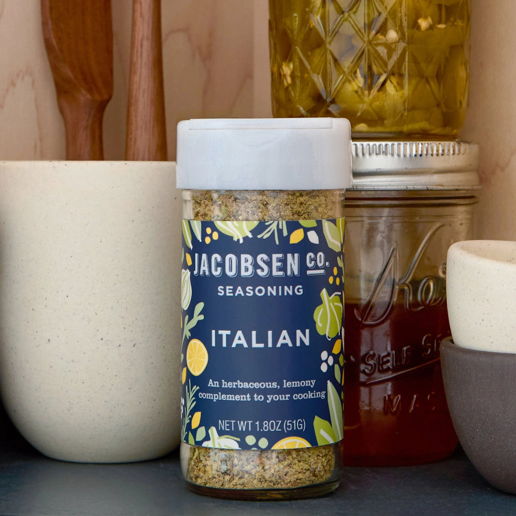 Jar of Jacobsen Co. Italian seasoning with kitchen items in the background