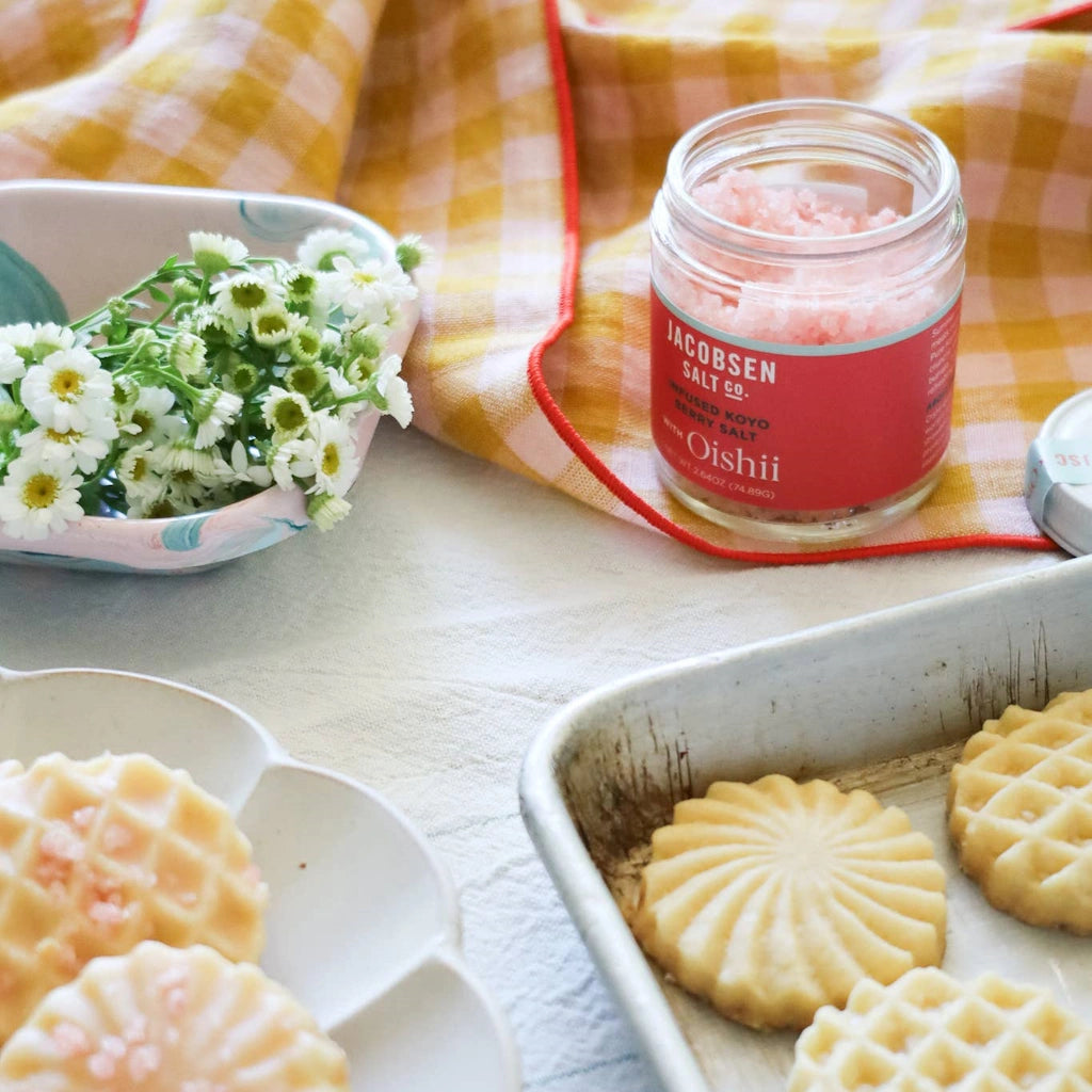 Jar of Jacobsen Salt Co. on a table with cookies and flowers