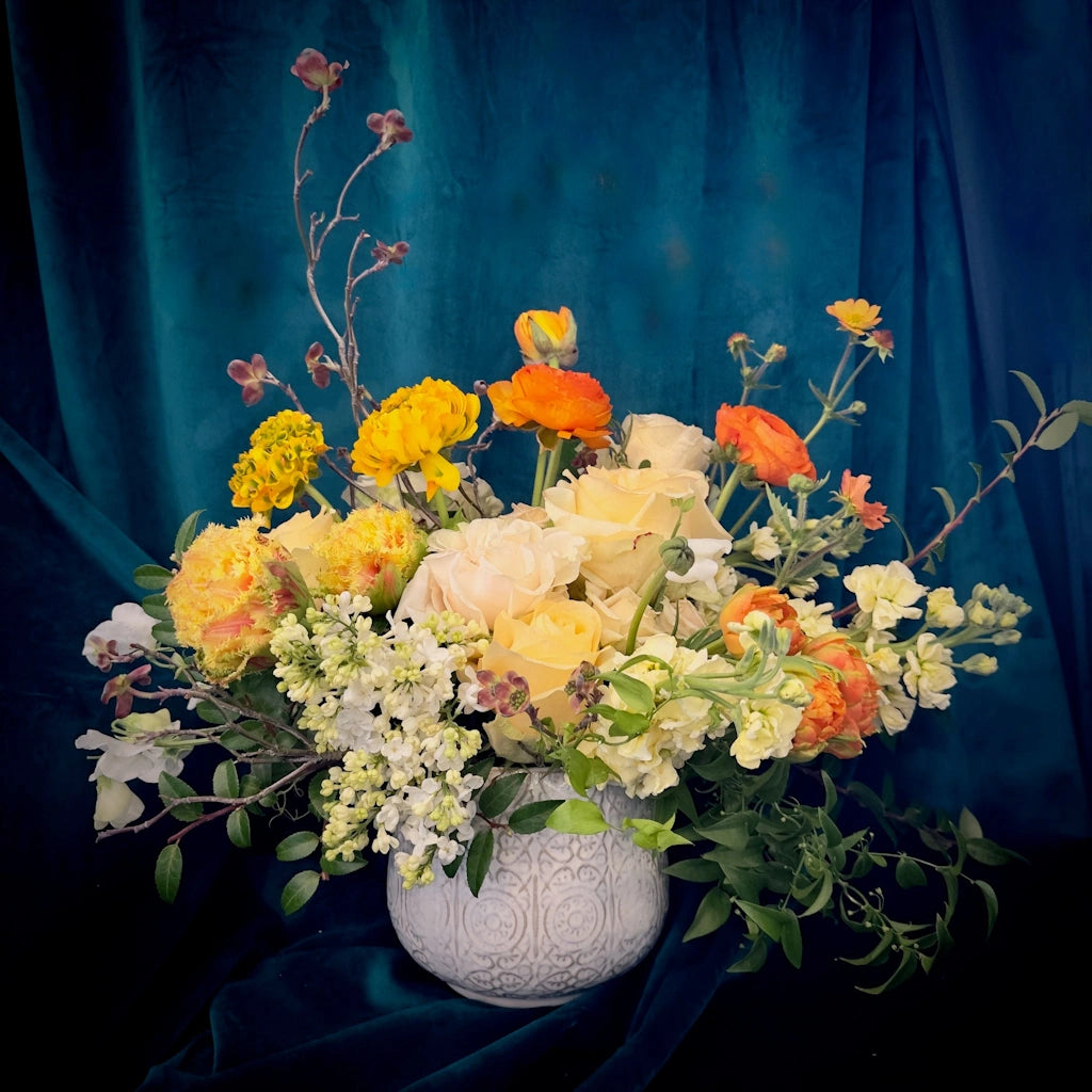 Campanula Design Studio's Floral arrangement "Lemonade Stand"invoikes sweet memories of childhood with citrusy tones of flowers designed in a ceramic vase.
