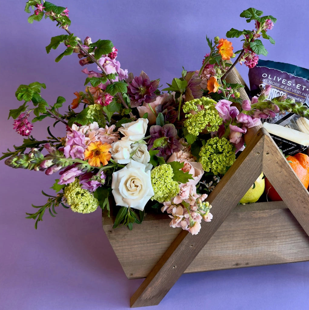 Bouquet of flowers in a wooden basket sold with customizable gifts by Campanula Design Studio of Seattle.