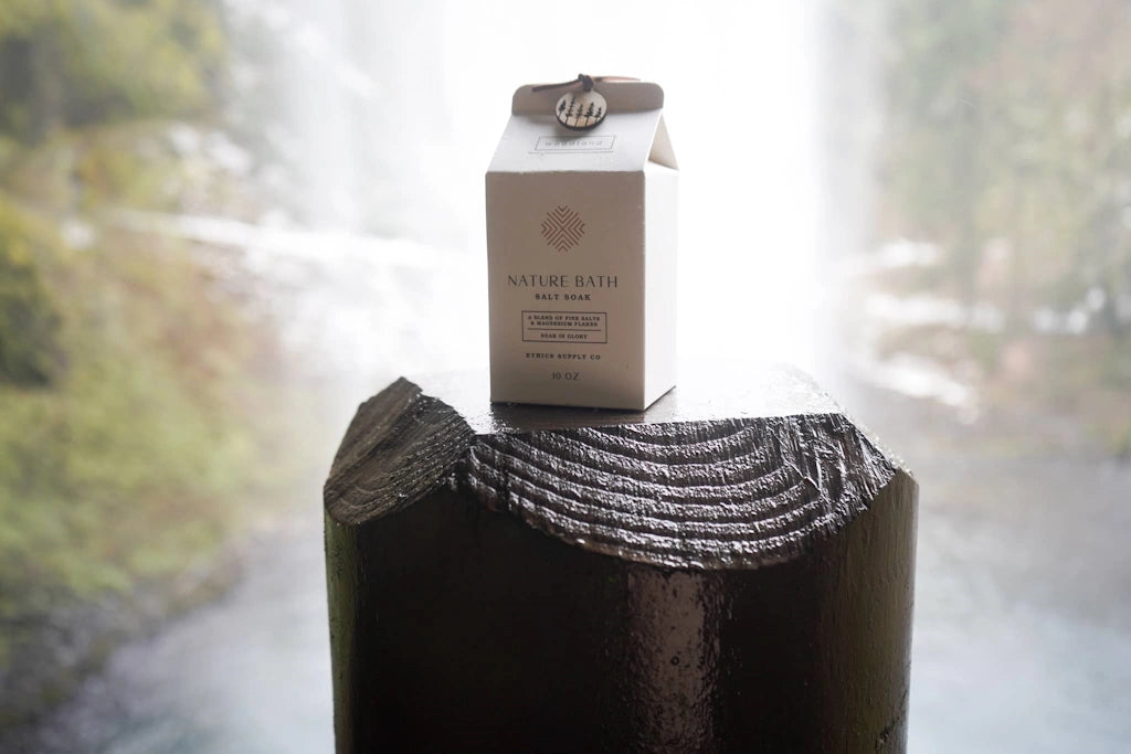 Carton of 'Natura Bath' soap on a wooden block with a blurred natural background