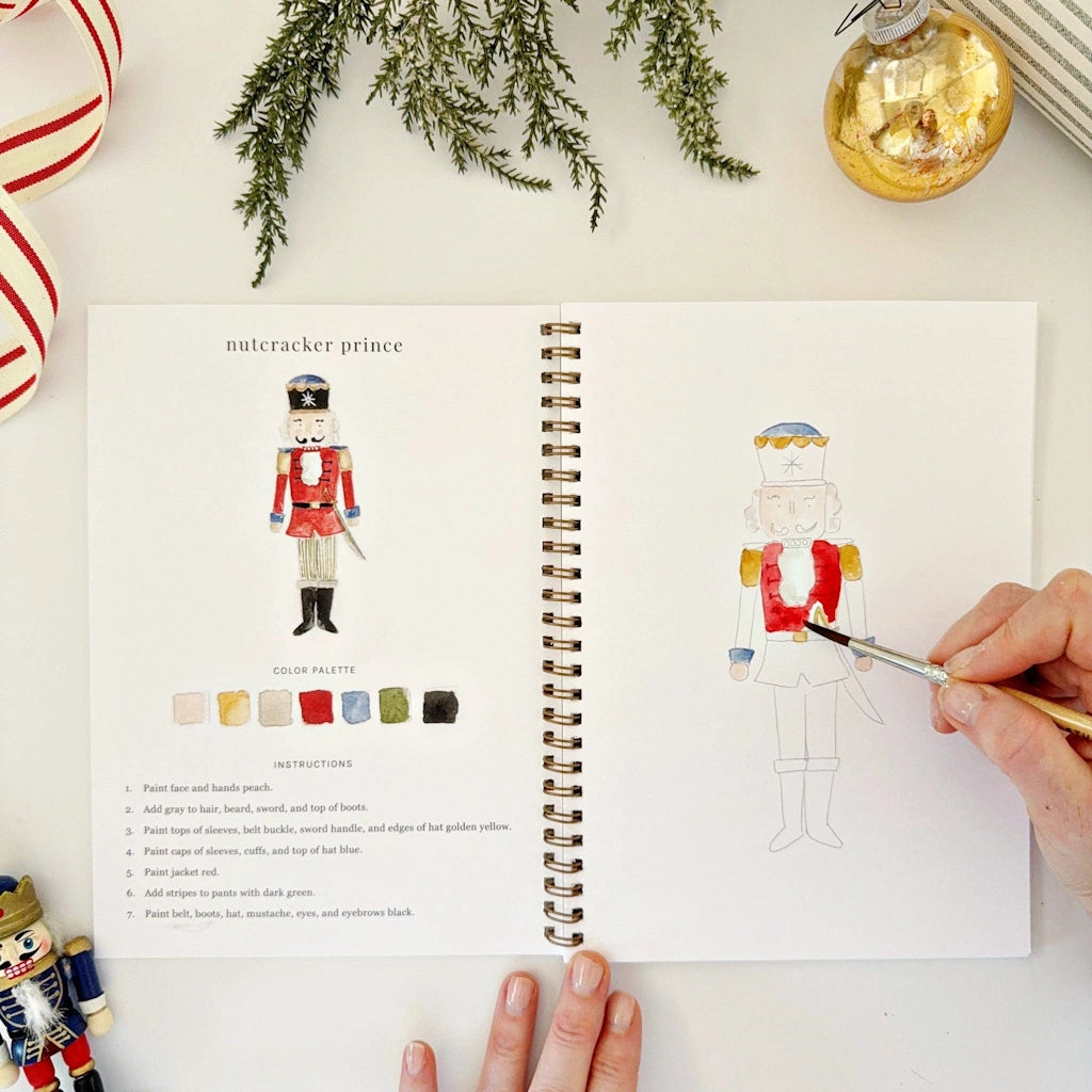 Open book with a Nutcracker illustration and color guide, surrounded by Christmas decorations.