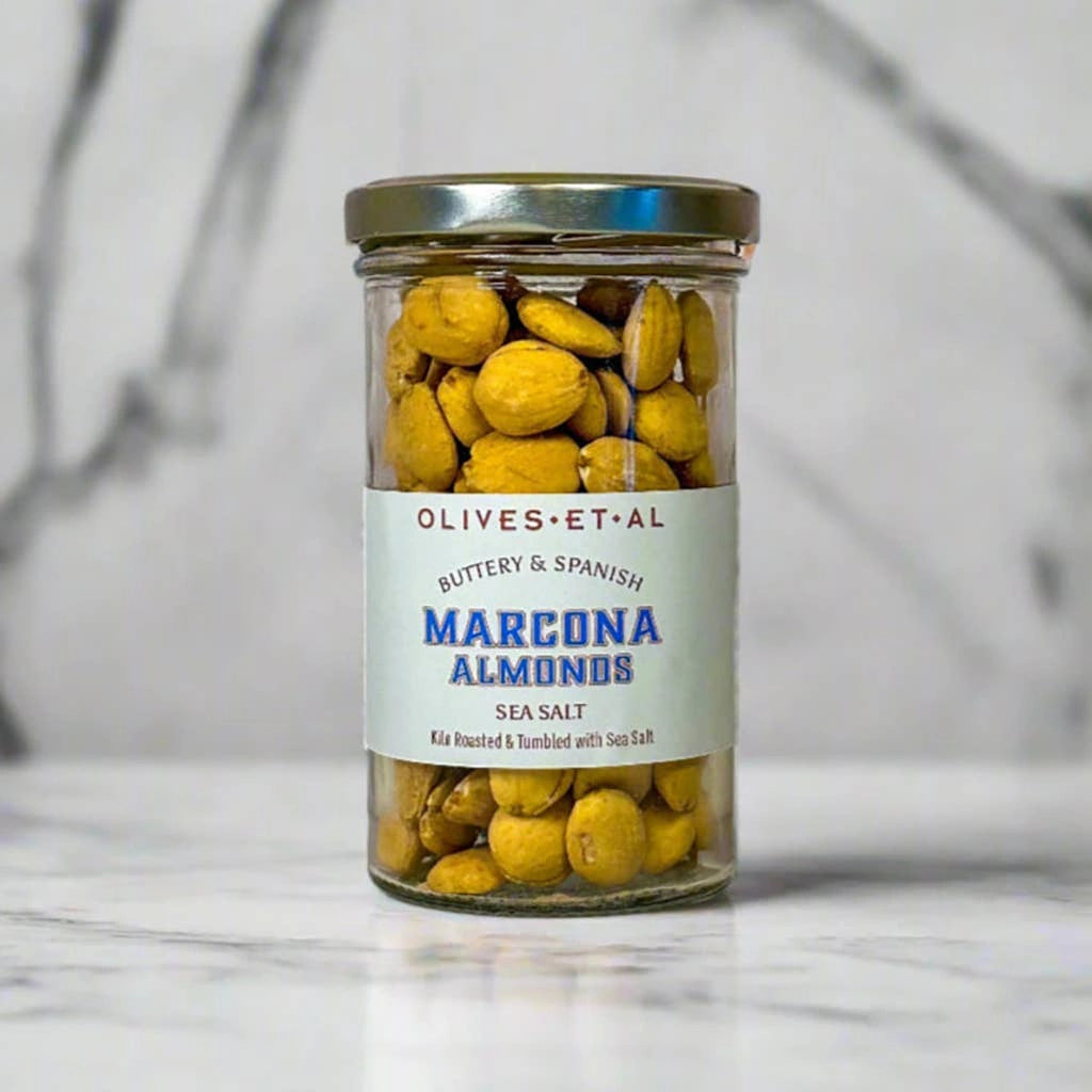 Jar of Marcona Almonds with a label on a marble surface