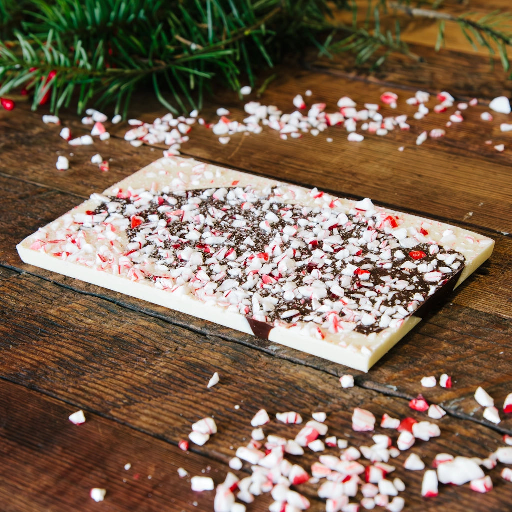 Chocolate bark with crushed peppermint candies on a wooden surface