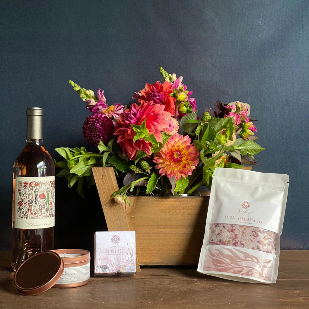 The Rosé Garden gift basket from Campanula Design Studios in Seattle features A floral of beautifully colorful seasonal blooms designed in our petit panier basket, your choice of a bottle of TÖST non-alcoholic sparkling rosé beverage or a bottle of Mark Ryan Flowerhead Rosé, Sealuxe Rose Bath Tea, Sealuxe Ritual Rose Soap and a Sealuxe Rose Gold Candle