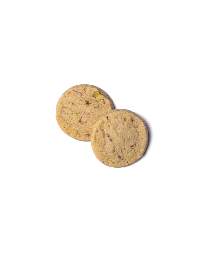 Two rose pistachio cardamom shortbread cookies with visible nuts on a white background