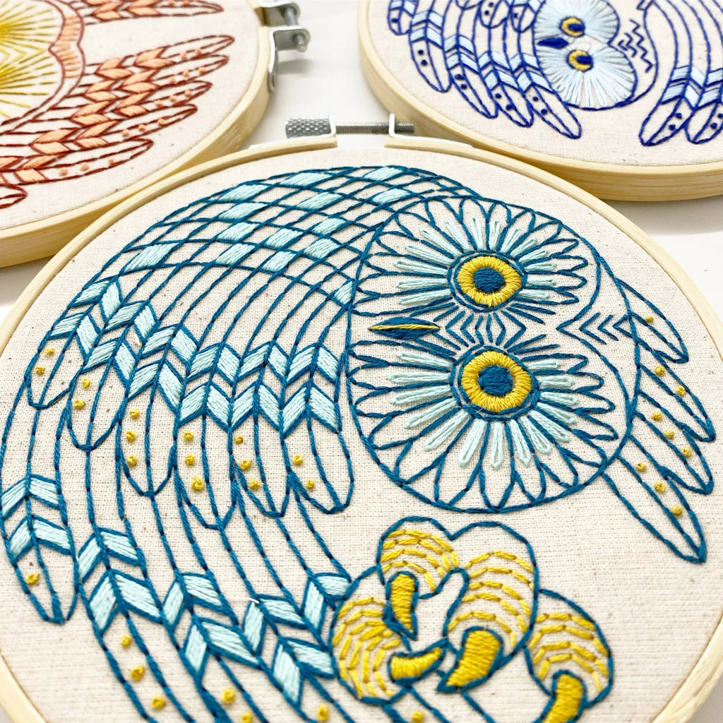 Embroidery hoops with owl designs on a white background