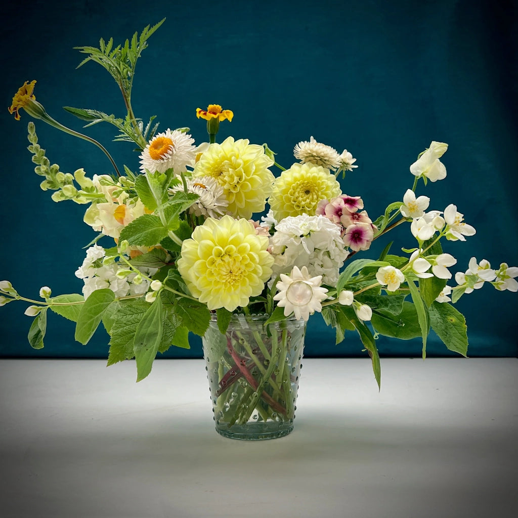 The "Simplicity" flower arrangement from Campanula Design Studios in Seattle features a warm palette of seasonal blooms and foliage designed in a simple hobnail vase.