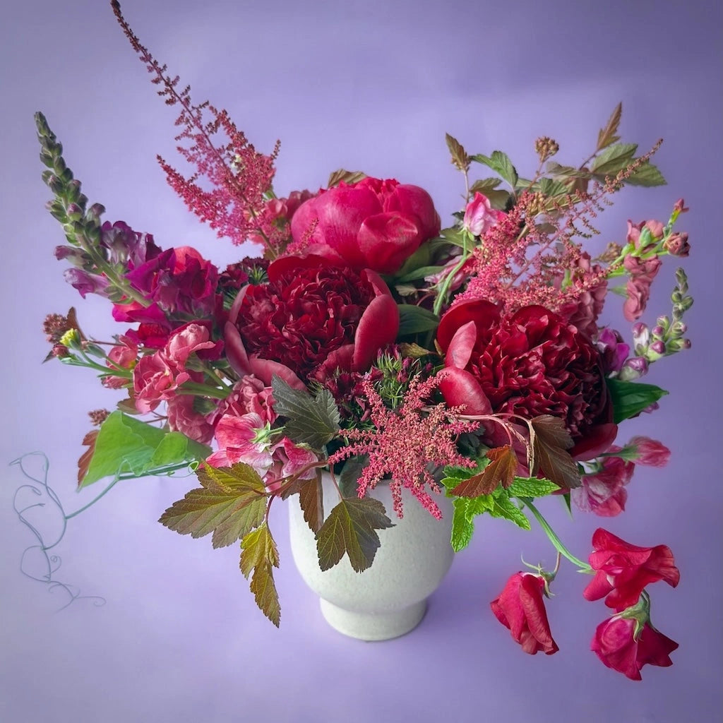 From Campanula Design Studio in Seattle - red bouquet of flowers in a white vase. The name of the arrangement is "Simply Red".