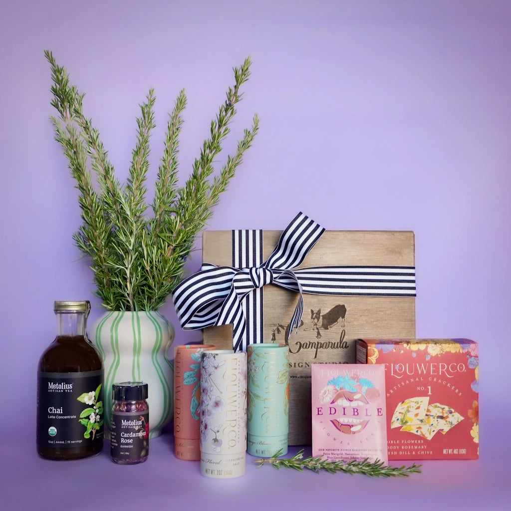 Collection of items including chai tea and edible floral gifts on a purple backgrounds.  Available for sale from Campanula Design Studio, Seattle florist and gift basket company in the Magnolia neighborhood.