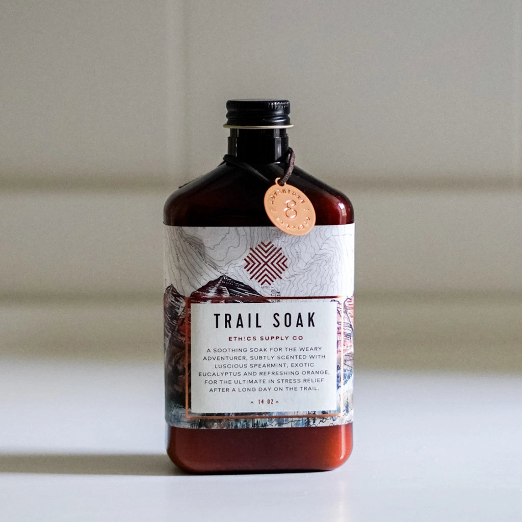 Bottle of 'Trail Soak' with a label on a neutral background
