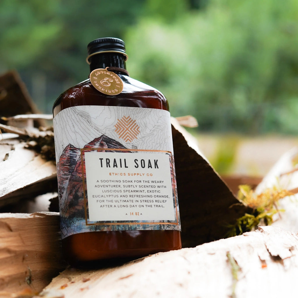 Trail Soak bottle with label on a wooden surface outdoors