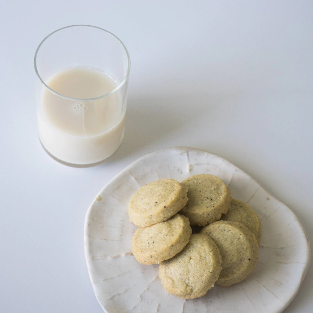 Shortbread Cookies on a plate with a glass of milk on a white background 