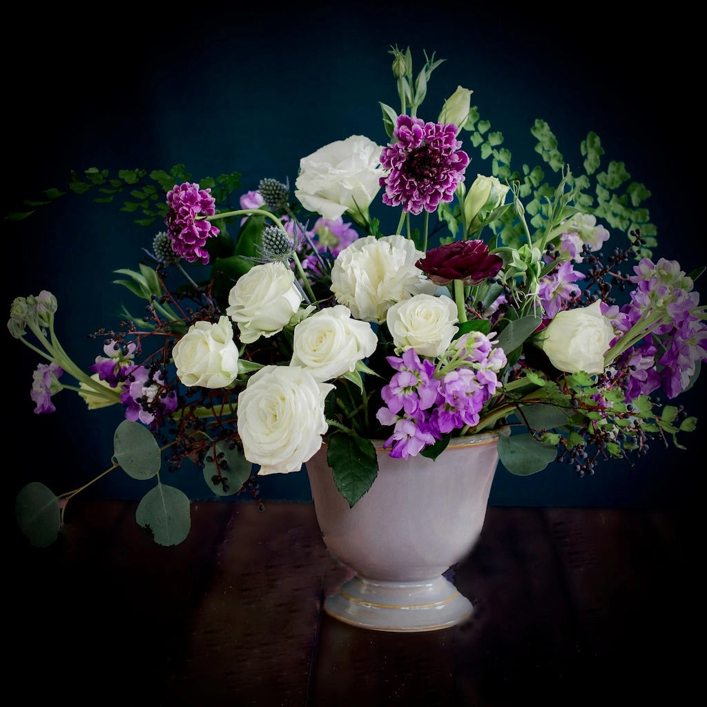 Campanula Design Studio's Violette floral arrangement features a soft palette of purples, blues, and whites designed in a ceramic vase.