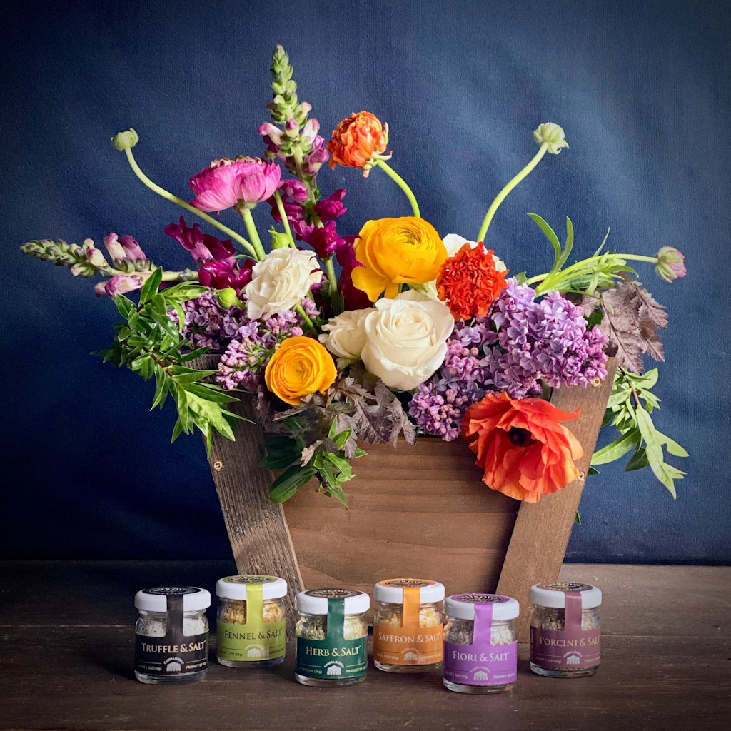 A custom handmade wooden gift basket by Seattle florist Campanula Design Studio. Includes a colorful bouquet of seasonal flowers and a set of mini salt jars.