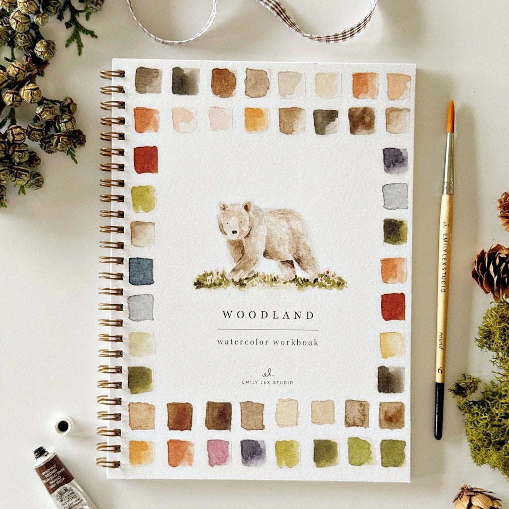 Notebook with bear illustration and watercolor swatches on a white surface with stationery items.  Available from Campanula Design Studio, Seattle florist and gift basket company in the Magnolia neighborhood.