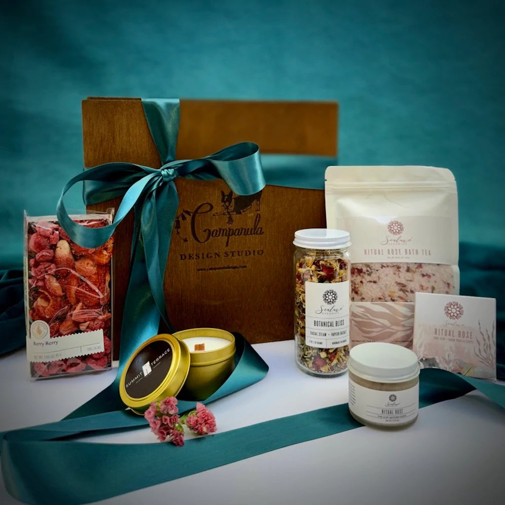 A custom curated gift box of Sealuxe spa products, Wildwood chocolate, and a candle from local Seattle maker Summit & Terrace designed in a handmade wooden gift box. By Seattle florist Campanula Design Studio.
